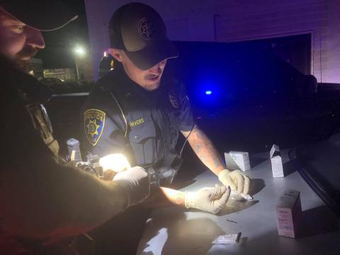 Authorities test a baggie of sheetrock to determine whether it contains traces of cocaine or heroin. 