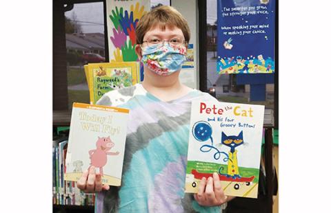Youth Services Librarian Bridget Wilson holds books featuring Piggie and Pete the Cat, the two candidates in the Kids’ Book Character Election at local libraries.