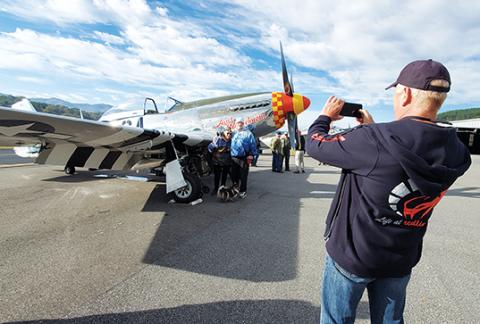 U.S. Air Force veteran Carol Kingsley poses with her son, John, in front of an AT-11 plane as Gary Carter takes their photo. Kingsley is a Korean War veteran who joined when the Air Force started to welcome women. Photo by Samantha Sinclair