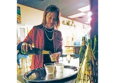 Lane Schreiber, owner of The Daily Grind & Wine in Murphy, pours champagne to hand out to guests during the 2019 New Year’s Eve celebration. Photo by Samantha Sinclair