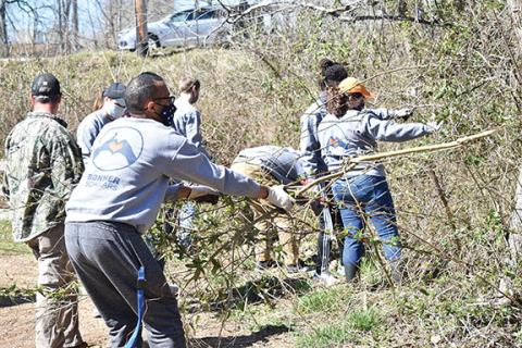 Alexander Nichols (left) and Jeremiah Ellison from Carson-Newman University work hard removing invasive plants from the Murphy River Walk, which allows native vegetation to flourish. 