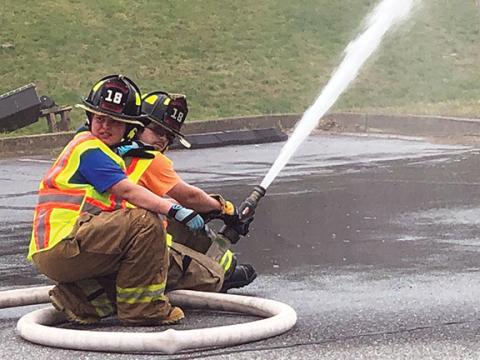 Penny Ray/pennyray@cherokeescout.com  Ranger volunteer firefighters Jewelia Crowe (left) and Dakota Thrower demonstrate the local department’s ability to sustain flow from a static water point in the Cherokee County Department of Social Services parking lot.