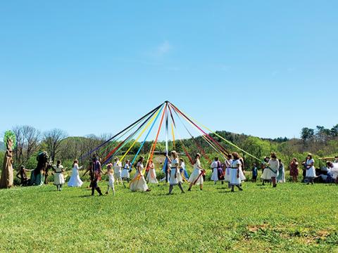 Photos by Stacy Van Buskirk/svanbuskirk@cherokeescout.com  The Brasstown Morris Dancers begin weaving multi-colored ribbons around the May Pole on Saturday at John C. Campbell Folk School in Brasstown.