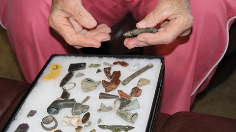 Thompson goes through the history behind some of the relics she found around the county. In this photo, she is holding a pendent that would have been worn to represent an old story about seven boys who turned into stars.