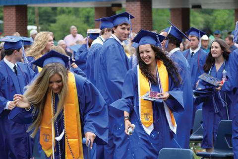 Stacy Van Buskirk/svanbuskirk@cherokeescout.com  Kiara Anderson sprays Dezeray Adams with Silly String after the graduation ceremony Saturday morning at Hiwassee Dam High School. Another photo, 7A.