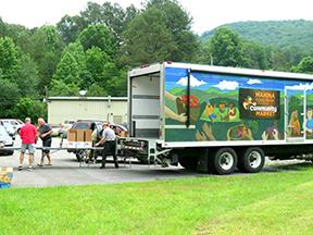 Volunteers like Art St. John and Michael Castaing help unload the MANNA Food Truck at the Hiwassee Dam Senior Center. The center hosts MANNA on the fourth Wednesday of every month to help the community.