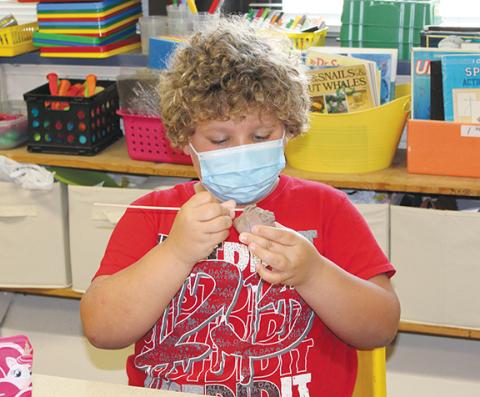 Stacy Van Buskirk/svanbuskirk@cherokeescout.com  Zayden Wallace, a rising fifth-grader, works closely blending the clay around the mouth of his pinch pot face during Mike Lalone’s class in the 21st Century Program at Andrews Elementary School on June 24.