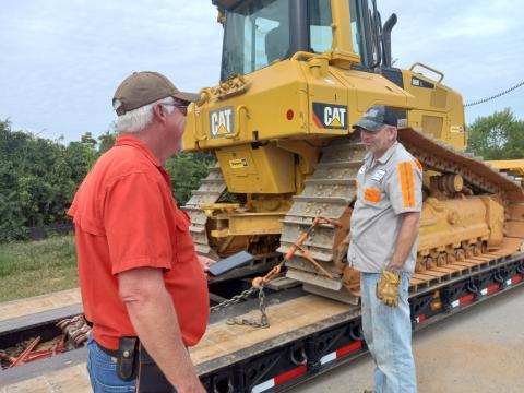 Site supervisor, Kelly Luther of Wells & West Construction (front), talks to Travis Wilson, a driver for Biggs Transport (rear). 