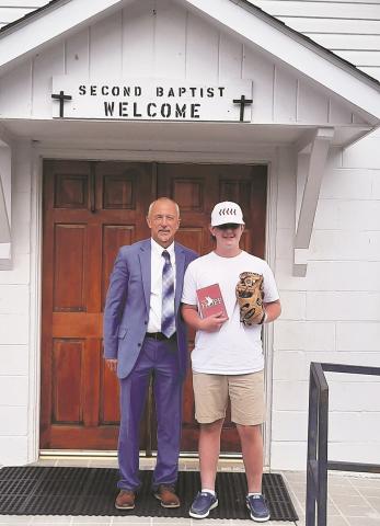 Pastor Chuck Davis and Ethan Sutton in front of the Andrews Second Baptist Church building.