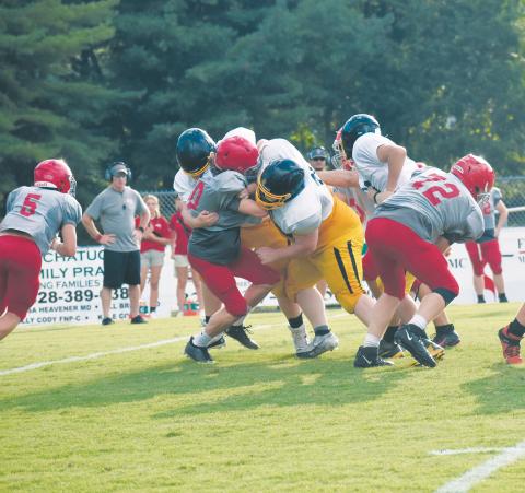 An Erwin runner is sandwiched by two Bulldogs.