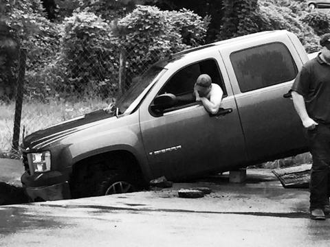 A sinkhole swallowed two trucks following heavy rains Aug. 17 in front of NAPA Auto & Truck Parts on U.S. 64 West in Murphy.