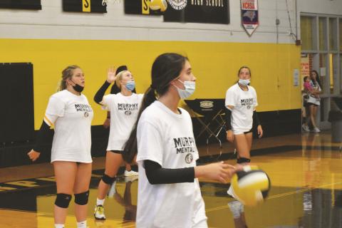 Murphy volleyball players wear masks while warming up for their match against Highlands on Aug. 19.