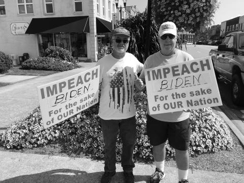 Don Adams and Dan Fogarty hold signs at the protest.