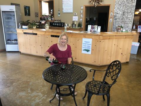 Jan Olson pours a glass of red wine inside FernCrest Winery.