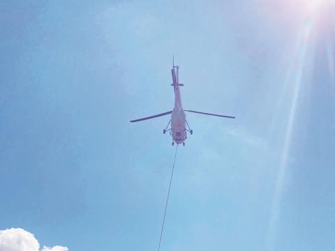A helicopter with the National Transportation Safety Board flies in wreckage from the Oct. 3 plane crash to Western Carolina Regional Airport on Friday.
