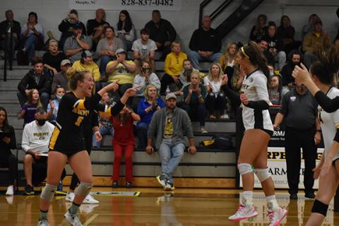 Murphy’s Cailey Dockery (left) celebrates with Olivia Payne (right) after a Dockery assist led to a Payne kill during the Lady Bulldogs 3-0 win over Rosman