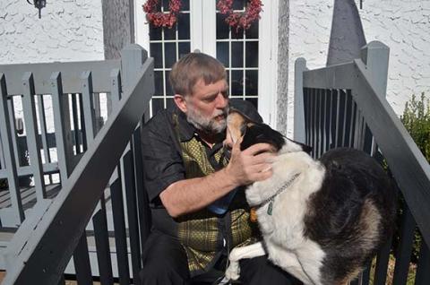 Abigail Hickman/Staff Correspondent Pastor Tim Huff with his service dog, Gus, enjoying each other and the nice weather outside Murphy Free Methodist Church.