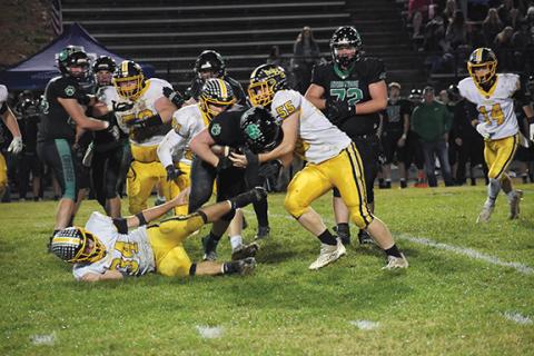 Justin Fitzgerald/sports@cherokeescout.com Murphy’s Joe Swain (55) starts to wrap up Mountain Heritage’s Logan Huskins during the Bulldogs’ 22-10 win over the Cougars on Friday night. Against Mountain Heritage, Murphy did not allow an offensive touchdown.