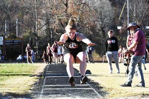 Photos by Justin Fitzgerald/sports@cherokeescout.com  Murphy indoor track returned to competition on Nov. 17. Lady Bulldogs senior Faith Ann Revis takes off (left) and lands (right) in the triple jump.