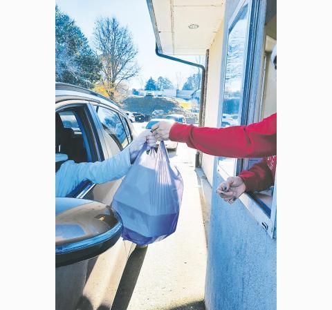 Bill Belian/Contributing Photographer A grateful diner receives a hot Thanksgiving Day dinner at no charge from the Main Street drive-through lane.
