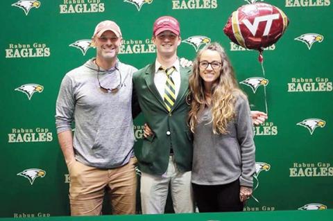 Andrews native Tucker Holloway smiles with his family after signing with Virginia Tech on Dec. 15. From left are Holloway’s father, Brody, Holloway and his mom, Little.