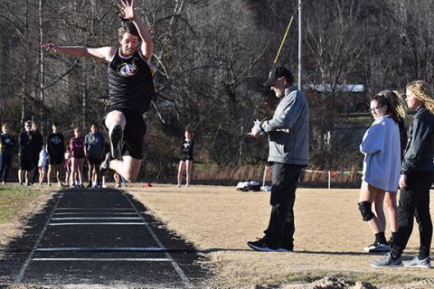 Murphy’s Christian Tighe lunges for the sand in the long jump during the Dec. 8 meet.