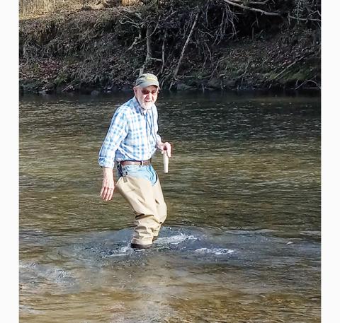 Tracy Barnes/Staff Correspondent Ken Kloeblen, 76, collects a sample from the Valley River, which is on the state’s list of threatened waters. 