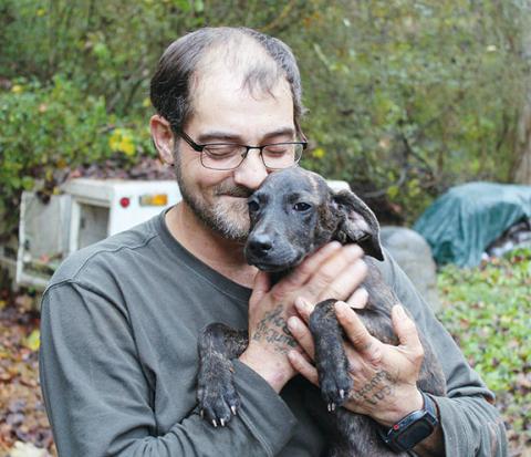 Tracy Barnes/For the Cherokee Scout Scotty Derreberry snuggles with a puppy at the Valley River Humane Society’s animal shelter in Marble. He takes care of puppies and small dogs under 25 pounds.