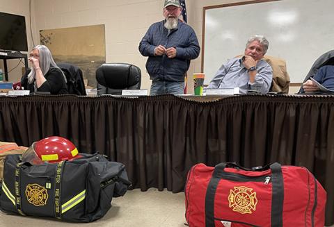 Jared Putnam/editor@cherokeescout.com Bags of fire gear sit in front of Mayor James Reid, along with Andrews Board of Aldermen members Brandi Smith and Steve Jordan, following the Jan. 18 meeting.