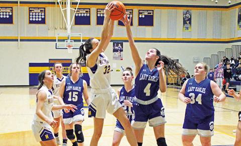Christopher Lugo/The Highlander Hiwassee Dam’s Rylie Payne battles for the ball with Highlands’ Ezra Banham during the Eagles’ 66-43 loss to the Lady Highlanders on Feb. 22. It was Hiwassee Dam’s fourth loss to Highlands this season. 