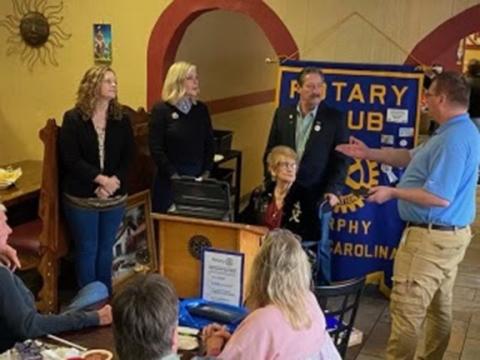Abigail Hickman (second from left) gets “pinned” into the Rotary Club of Murphy during a meeting last year.