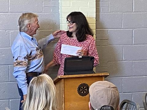 David Brown/dbrown@cherokescout.com Bob Massey (left) hands a check to Janet Drew, mother of the late Nora Starks, at the Rotary Club of Murphy’s meeting Monday. The money will build a well in Kenya.