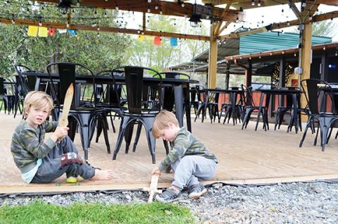 Abigail Hickman/Staff Correspondent GW McCurdy (5) and his younger brother, Gus (3), play with their swords on the outdoor patio of The Crown in Brasstown just before it fills with patrons.