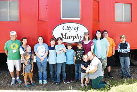 Photos by Bill Belian/Contributing Photographer  President Thomas Urso of the Valley River Model Railroad Club (far left) stands with students from Hidden Mountain Brilliance on May 17 at the L&N Depot in Murphy.
