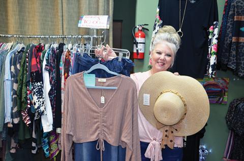 Abigail Hickman/Staff Correspondent Jody Quillian, owner of Glitz & Glamour Boutique in Murphy, holds up one of the fashion pieces included in the Wear the Care fashion show coming to The Ballroom at 6 p.m. Thursday.