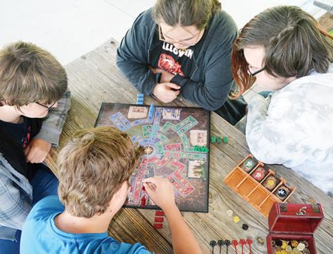 Abigail Hickman/Staff Correspondent Tom Spencer watches students Mylan Dockery, Carter Swafford, Manuel Rabon and Jacob Phillips play his invented board game, Castle Odyssey.