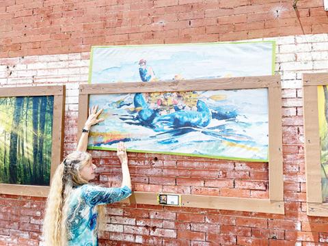 Abigail Hickman/Staff Correspondent Debra Vanderlaan of the Valley River Arts Guild elevates local artist Marie Spaeder Haas’ work as part of the Main Street Community effort.