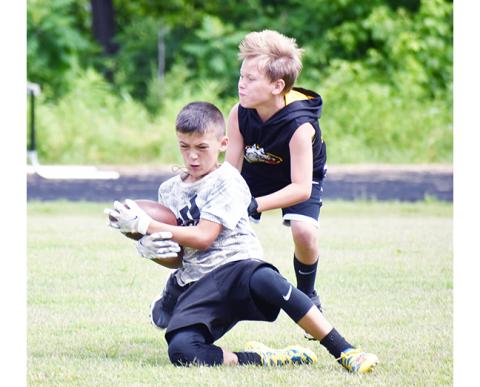 Justin Fitzgerald/sports@cherokeescout.com A total of 47 kids from age 7 through rising ninth-graders attended Murphy’s youth football camp from May 31 until Friday. Above, Wyatt Coleman steps in front of Brady Watson to break up a pass.