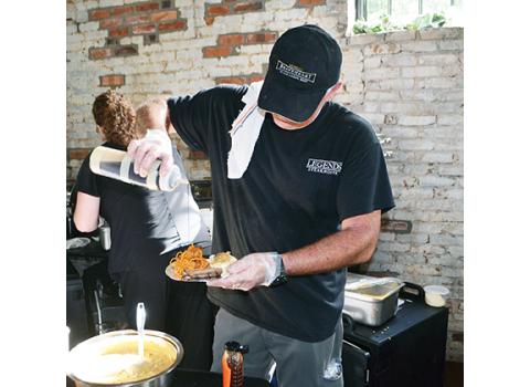 Photos by Abigail Hickman/Staff Correspondent Legend’s chef Matt Jones pours honey on chicken and waffles at Forks & Corks on Thursday night.