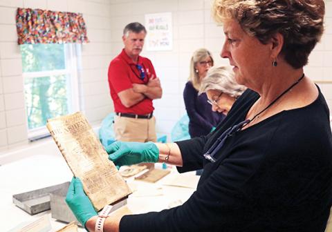 Charlene Smith checks out items pulled from a time capsule that lay buried inside Murphy First United Methodist Church for 100 years.