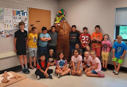 Bigfoot (otherwise known as local artist Mike LaLone) poses with students at Andrews High School on July 19.