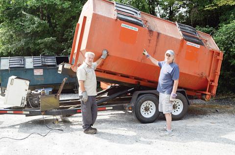 Abigail Hickman/Staff Correspondent Process driver David Antunes and convenience center attendant Joe Rather prepare the aluminum can collection bin for transport.