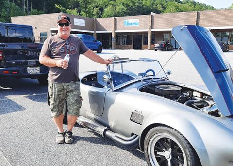 Wayne Agamie stands by his 1965 Shelby Cobra during the auto show July 20 in the parking lot of the Comfort Grub restaurant in Ranger.