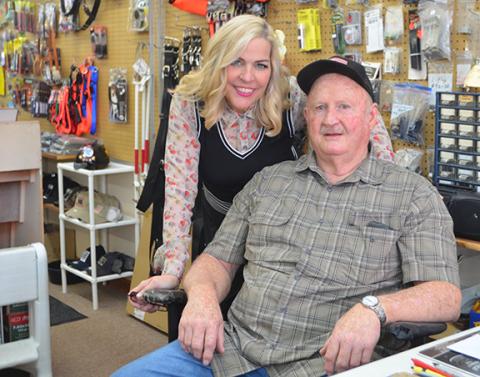 Abigail Hickman smiles with Harold Helton inside his bustling shop H&H Sports in downtown Murphy.