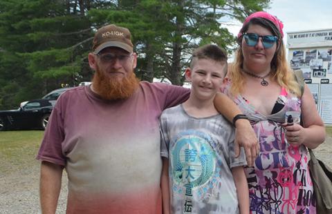 Young radio hobbyist Alex Bear, 11, is flanked by his parents, Alex Bear and Holly Franks, during the Western Carolina Amateur Radio Society’s Field Day on June 23 at Fields of the Wood in Hiwassee Dam.
