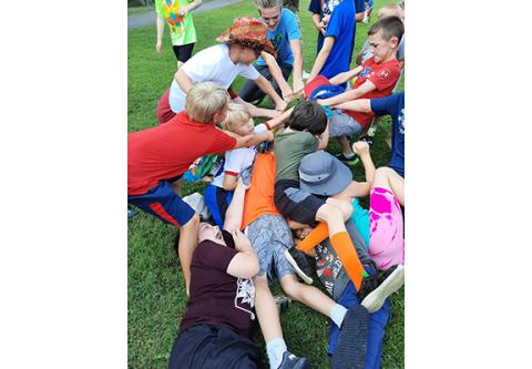 A pile of youngsters toss themselves onto an empty peanut bag that was discarded by the airplane after the drop during Murphy’s Fourth of July celebration Monday.