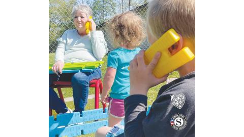 Linda Penland, a volunteer with the Foster Grandparent Program with Mountain Projects, has a serious plastic phone conversation with a student.