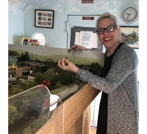 Abigail Hickman holds a prop from the model train set inside the L&N Depot in Murphy.