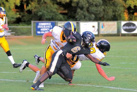 Murphy’s Ty Laney tries to bring down Commerce’s Jaiden Daniels during the Bulldogs’ 15-14 win over the Tigers on Friday night.