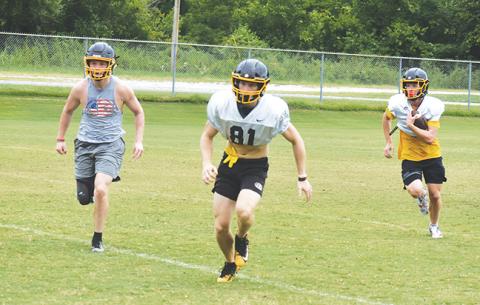 John Ledford (left) and Will Johnson (center) try to pave a path for Hunter Stalcup (right) during Murphy’s practice Thursday. All three are expected to play major roles for the Bulldogs this season.